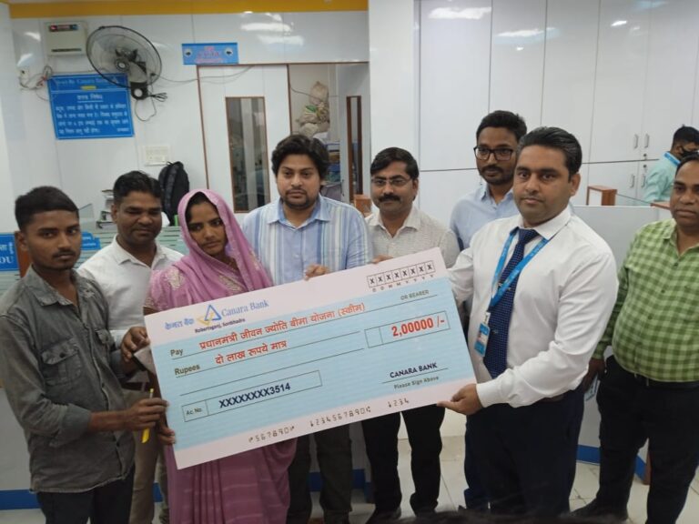 केनरा बैंक ने प्रधानमंत्री जीवन ज्योति बीमा योजना के तहत लाभार्थी को दिए दो लाख का चेक